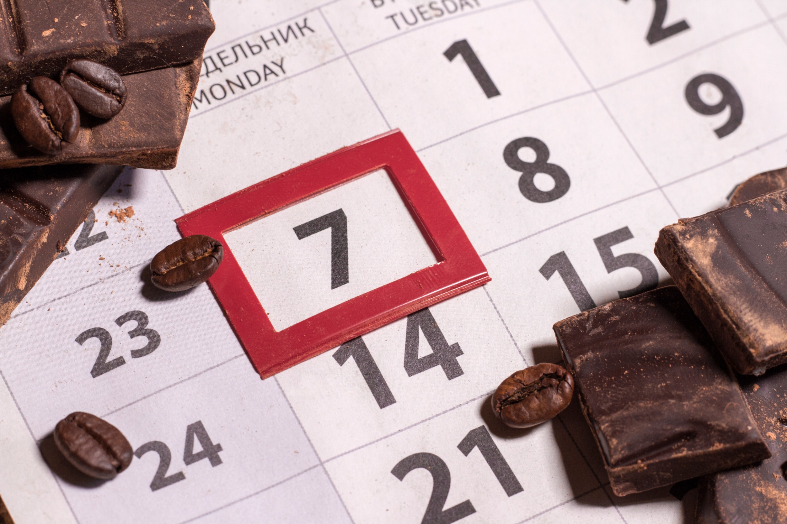 Calendrier avec la date 7 entouré de rouge sur laquelle est posée des grains de chocolat