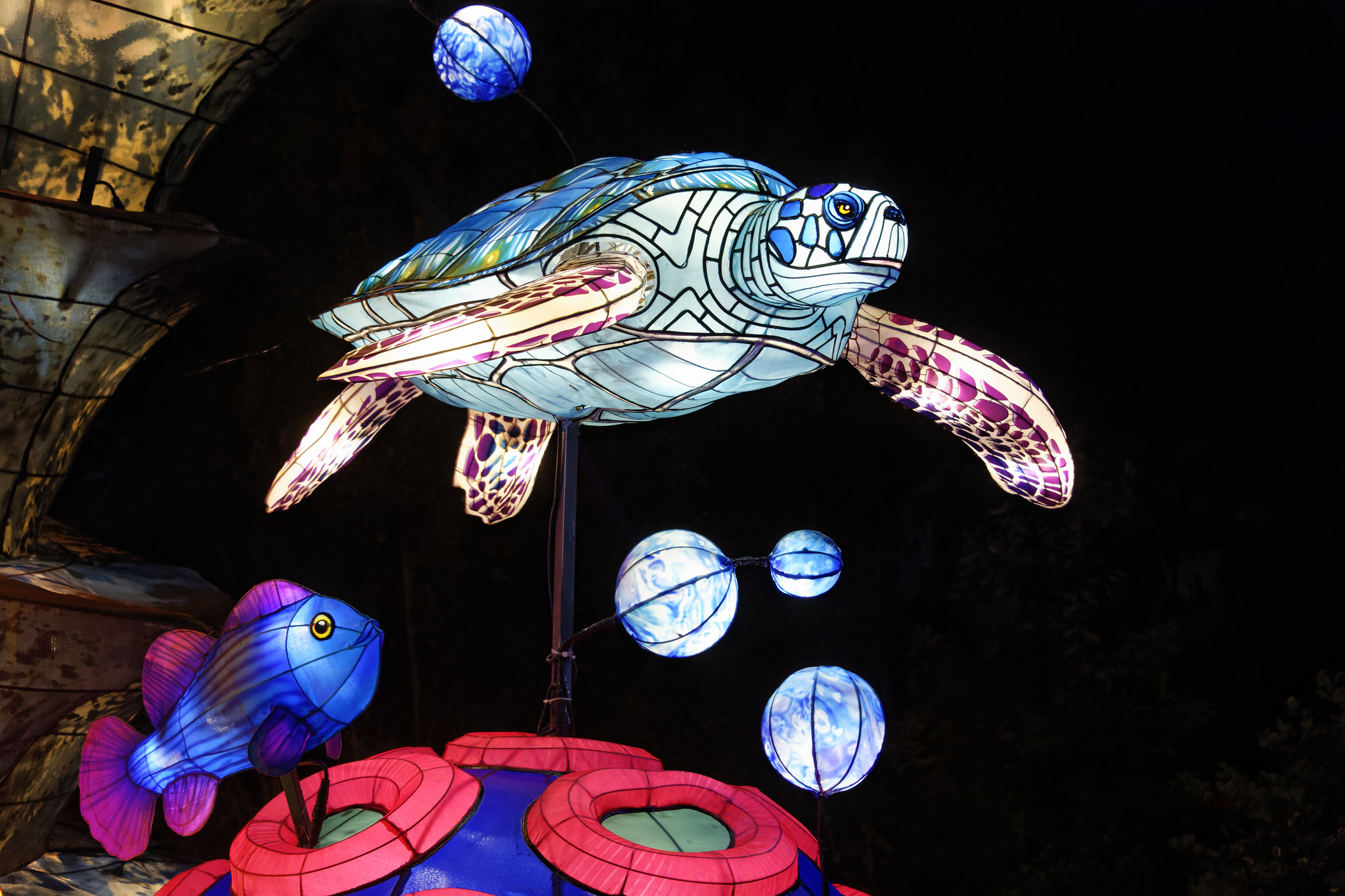 Photo en contre plongée d'une lampe suspendu en forme de tortue géante exposée au jardin des plantes pendant l'illumination