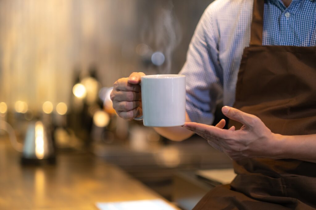 Un homme tient une tasse de café entre les mains