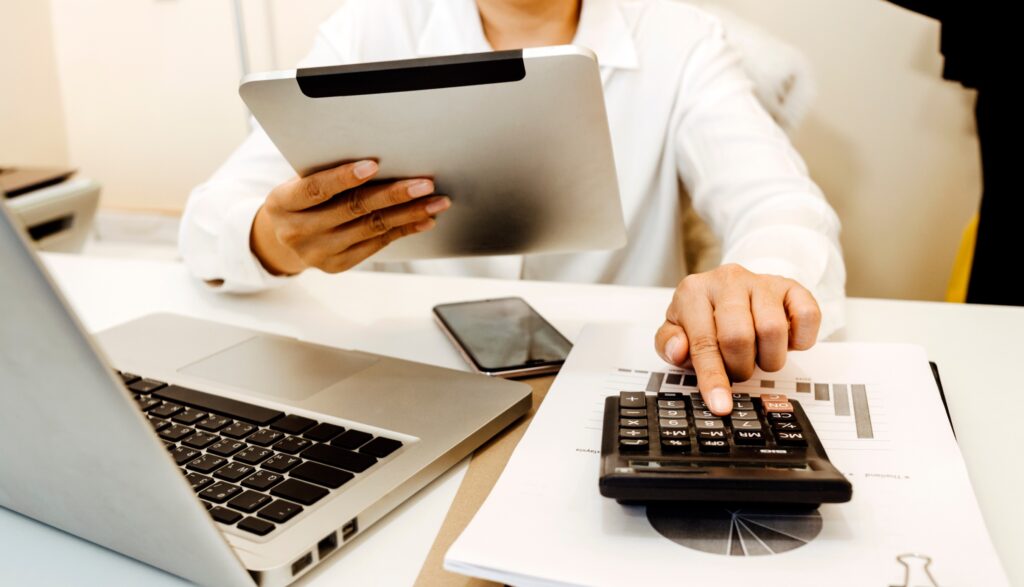 Business man faisant un calcul avec une calculatrice et une tablette sur son bureau