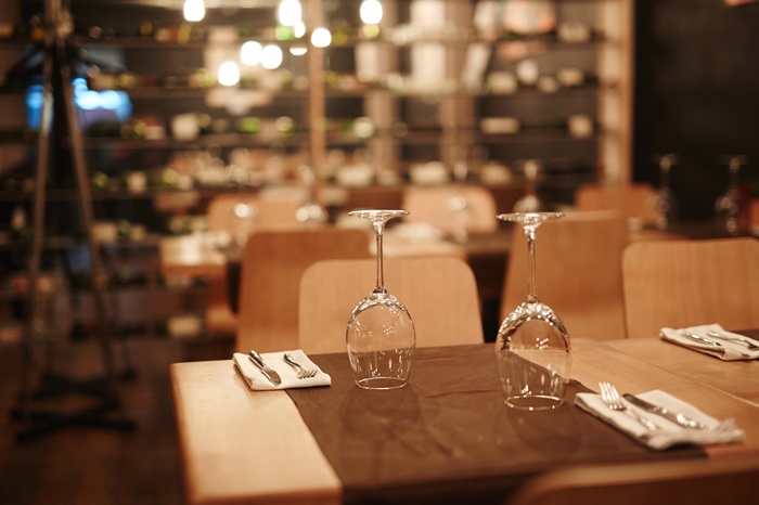Table vide dans un restau chic avec verres à vin et couverts en attente d'invités