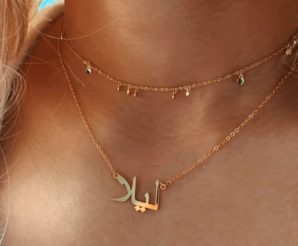 un collier prénom arabe ras le cou sur le cou d'une jeune fille. Gros plan sur le colleir