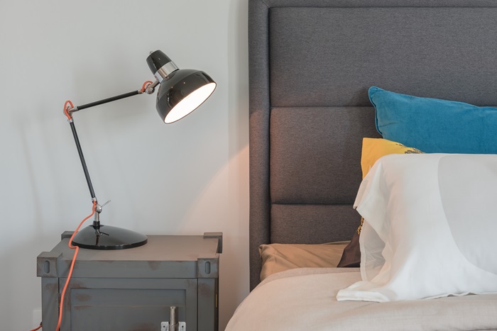 une lampe de chevet moderne modulable à coté d'un lit