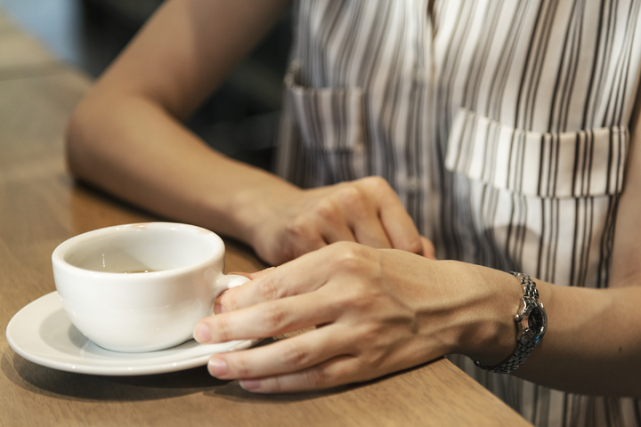 Gros plan sur les mains d'une femme tenant une tasse de café