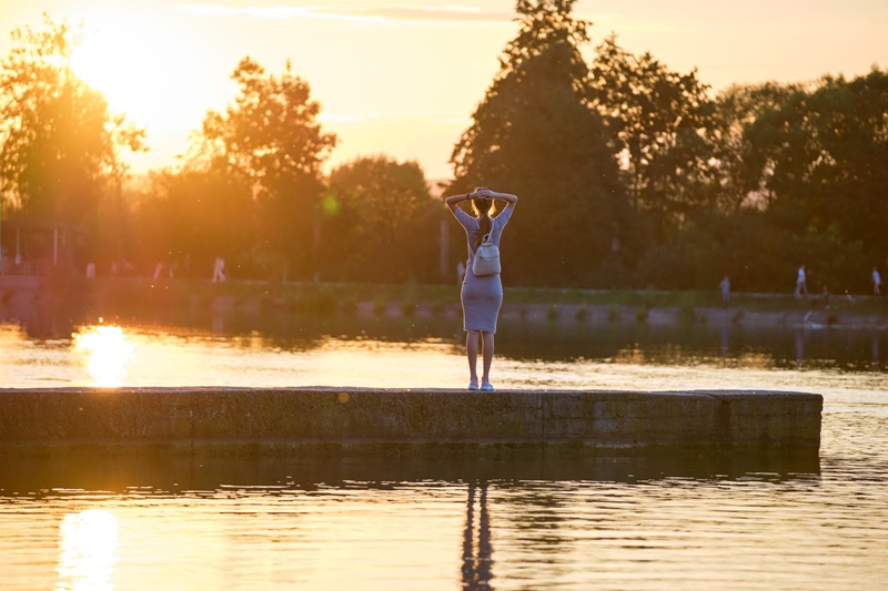 Une femme admire le coucher du soleil