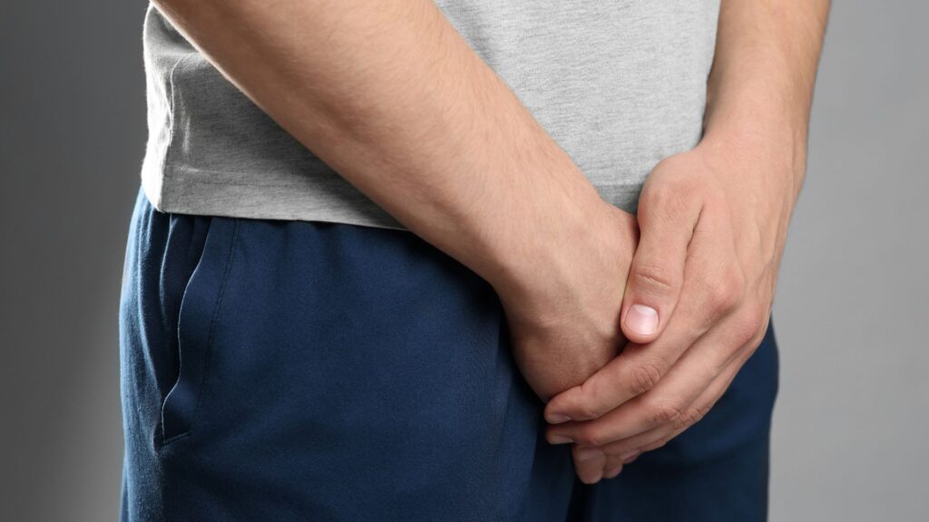 Homme qui a les mains sur sa culotte