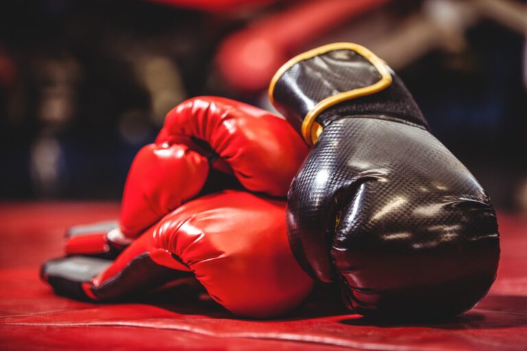 Paire de gants de boxe noirs et rouges sur un ring de boxe