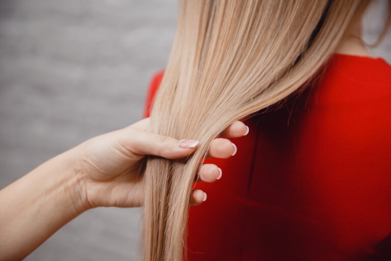 Photo gros plan, vue de dos, d'une femme avec des cheveux mi-long tenue par une main