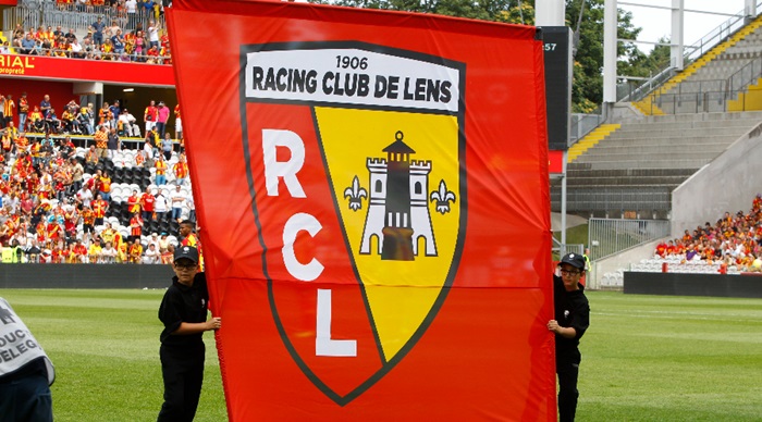 La bannière du Racing Club de Lens, tenu par 2 sportif au milieu de terrain avant le démarrage du match