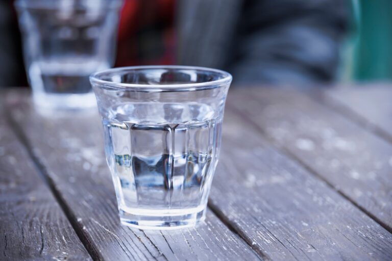 Eau pure et clair adoucis dans un verre posé sur une table en bois. Concept d'adoucissement de l'eau