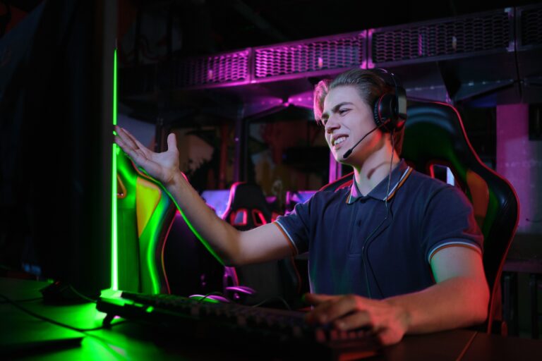 Jeune joueur de e-sport en plein jeux devant son pc