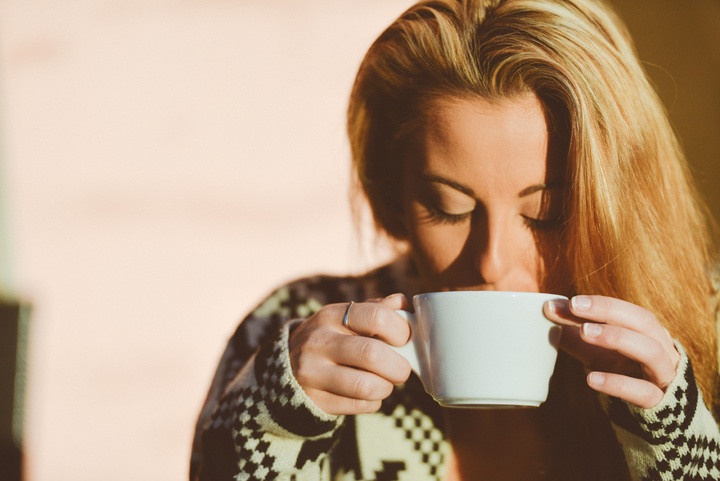 Au réveil, une jeune femme boit son café le matin
