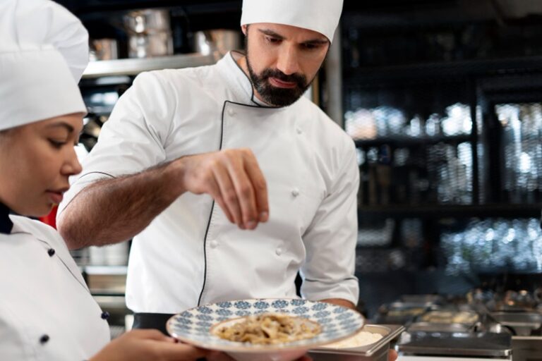 Un chef cuisniser français assaisonne un plat, gros plan sur ses doigts