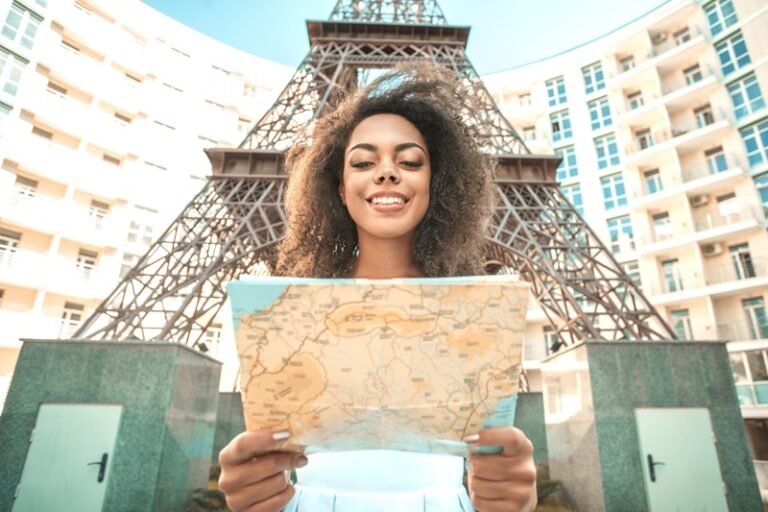 carte de France, dans les mains d'une femme, devant la tour Eiffel