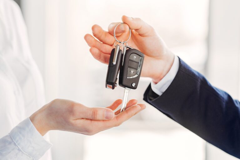 un homme remet une clé de location voiture pas cher avec turo à une femme